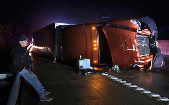 Mark Nelson, of Wis., waits with his tractor-trailer after it overturned during high winds and a possible tornado on Interstate 44 westbound at Villa Ridge, Mo., Friday, March 14, 2025. (Robert Cohen/ ...