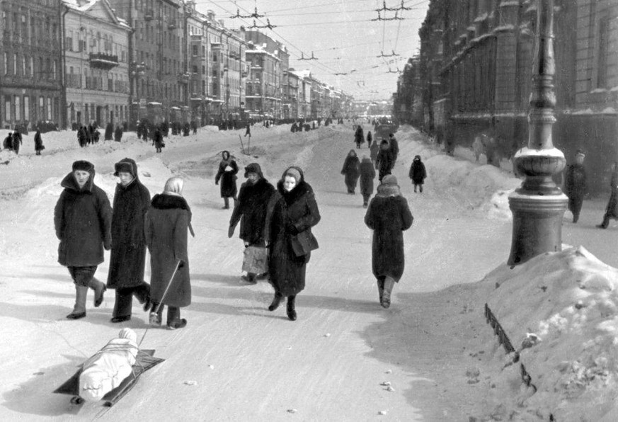 Eine Frau zieht eine Leiche auf einem Schlitten den Newski-Prospekt hinunter, Leningrad, Februar 1942.