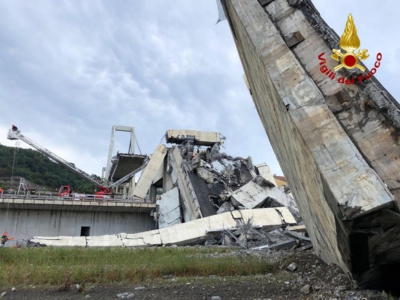 epa06949284 A handout photo made available by Italian firefighters shows rescue teams on the site of a collapsed bridge over the A10 highway in Genoa, Italy, 14 August 2018. At least 22 people are bel ...