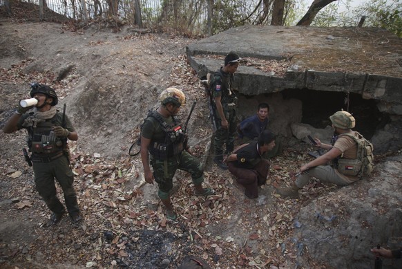 Members of the Karen National Liberation Army and People?s Defense Force examine two arrested soldiers after they captured an army outpost, in the southern part of Myawaddy township in Kayin state, My ...
