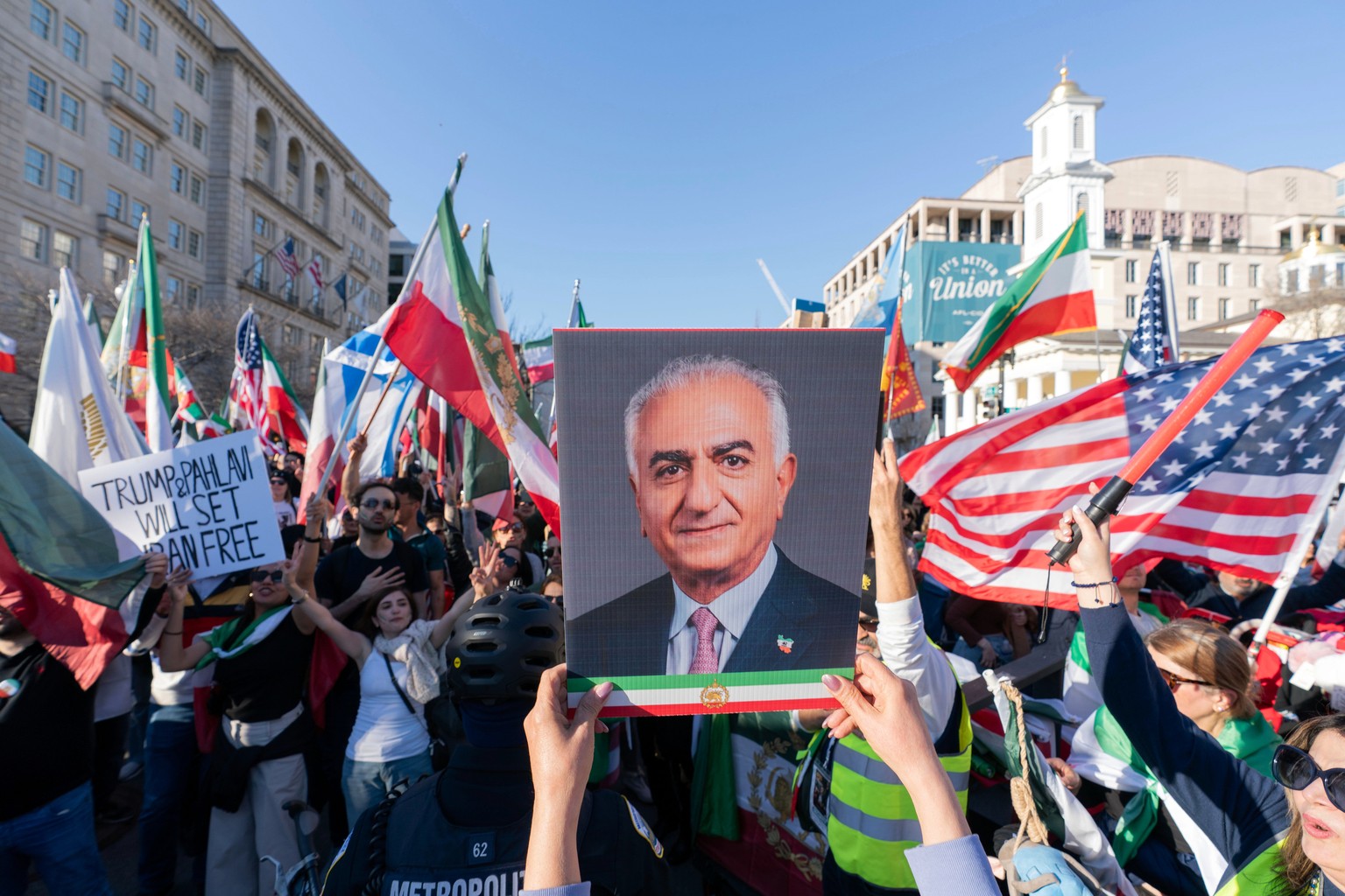 A demonstrators holds a photograph of Reza Pahlavi as people who support the U.S. and Israel strikes on Iran, rally near the White House, Saturday Feb. 28, 2026, in Washington. (AP Photo/Jose Luis Mag ...