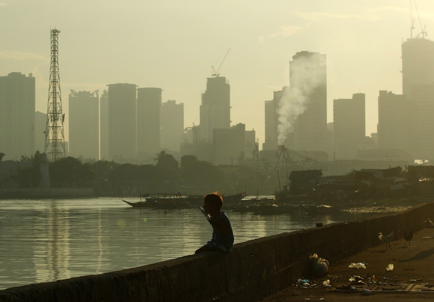 epaselect epa08451144 A Filipino boy eats a food pack during a coronavirus pandemic at a slum area in Manila, Philippines, 28 May 2020 (issued on 29 May 2020). On the way to the longest confinement wo ...