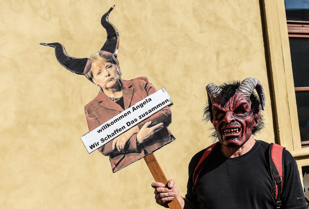 epa05509887 A protester holds up a banner reading 'Together we can do it' during a demonstration against German Chancellor Angela Merkel in Prague, Czech Republic, 25 August 2016. German Cha ...