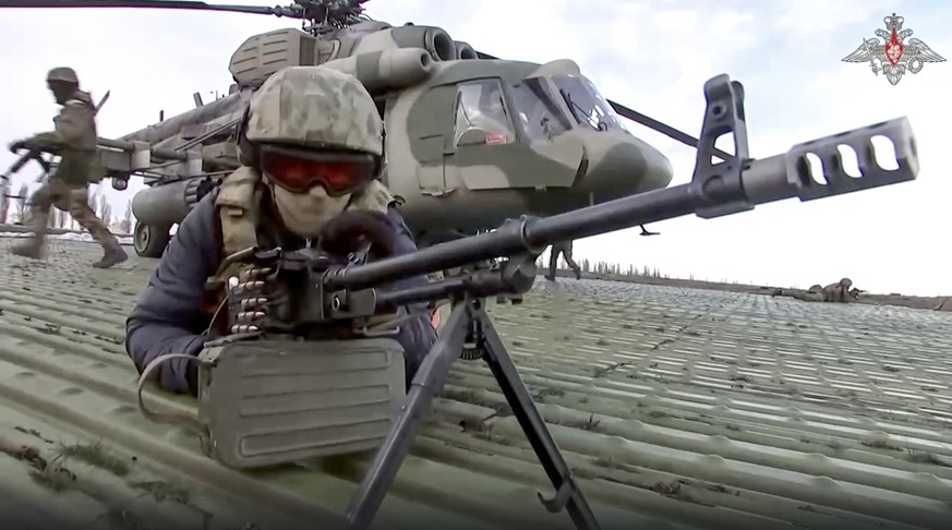FILE - In this handout, a photo is taken from a video released by the press service of the Russian Ministry of Defense on Tuesday, December 12.  On February 6, 2022, Russian soldiers take their position upon landing at an unspecified place...