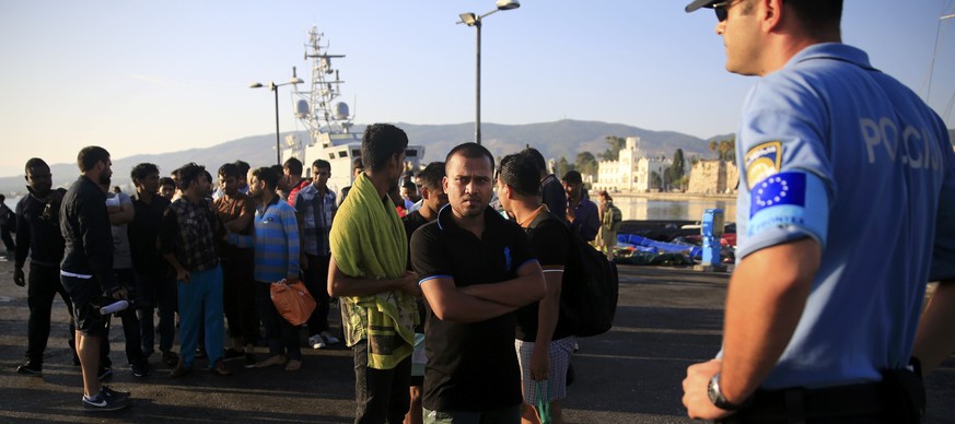 Ein Beamte der europäischen Grenzschutzagentur Frontex nimmt auf der griechischen Insel Kos Flüchtlinge in Empfang.