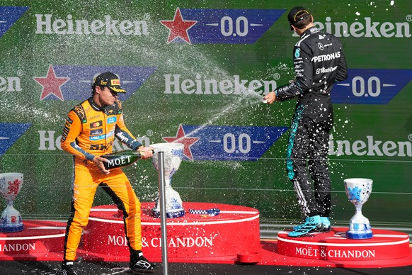 First-placed McLaren driver Lando Norris of Britain and third-placed Mercedes driver George Russell of Britain spray cjampagne on the podium after the Formula One Dutch Grand Prix in Zandvoort , Nethe ...