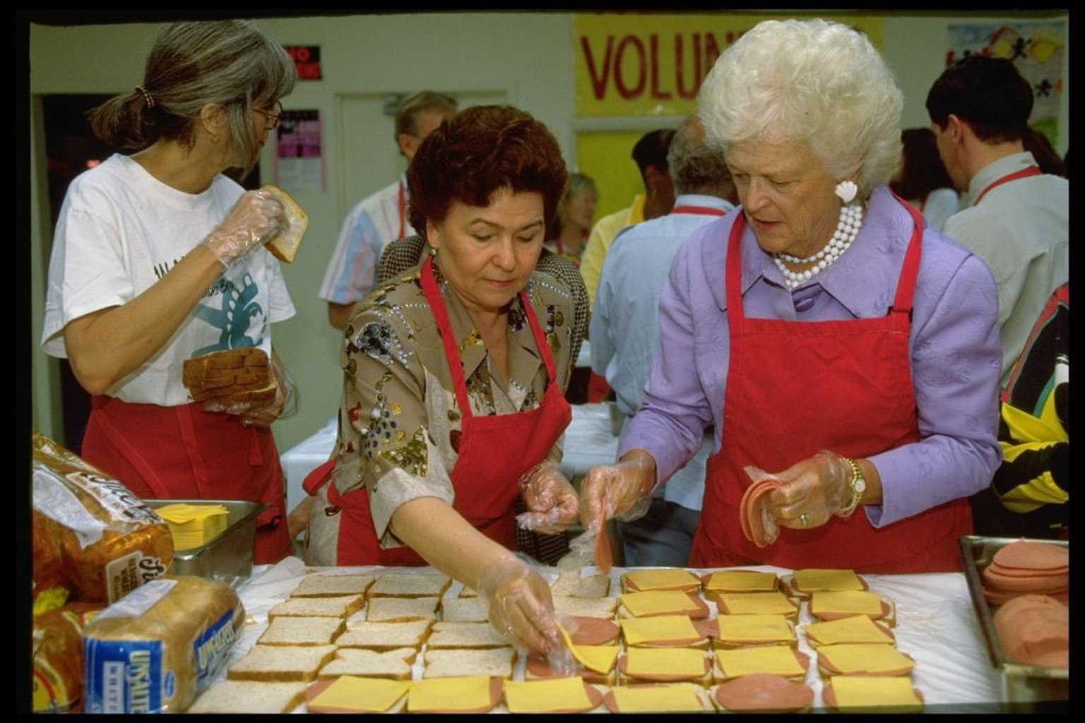 Russian First Lady Naina Yeltsin (L) and her summit hostess Barbara Bush (C) making bologna and cheese sandwiches for distribution to the homeless in city parks, in a visit to Martha's Kitchen, a ...