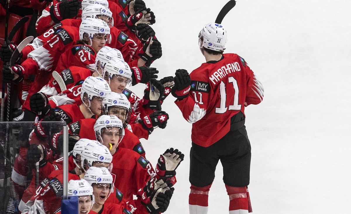 Switzerland's Lionel Marchand (11) celebrates his goal against Austria with teammates during the third period of a game in preparation for the IIHF World Junior Hockey Championships, in Edmonton, ...