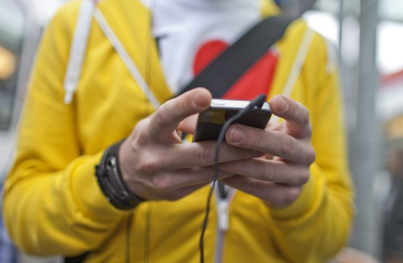 THEMENBILD --- Ein Mann bedient sein iphone vor der Bahnhof Enge in Zuerich, aufgenommen am 3. Juli 2012. Am Bezirksgericht Horgen ZH wird seit Mittwoch, 7. Mai 2014 der erste grosse Sexting-Fall der  ...