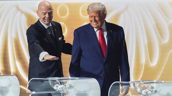 President Donald Trump is greeted by FIFA President Gianni Infantino during the draw for the 2026 soccer World Cup at the Kennedy Center in Washington, Friday, Dec. 5, 2025. (AP Photo/Jacquelyn Martin ...