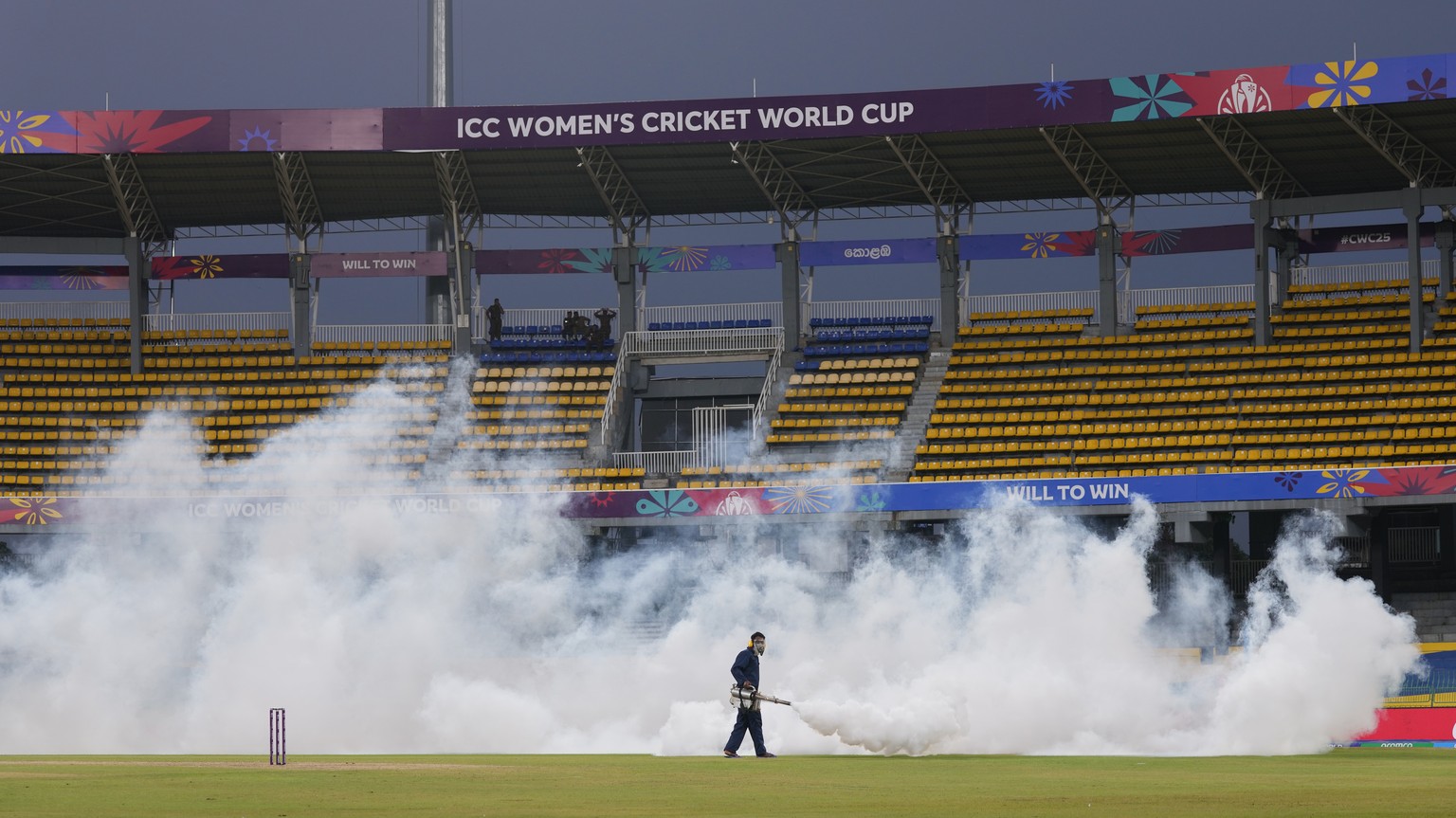 A worker fumigates the field during the ICC Women's Cricket World Cup match between India and Pakistan at Premadasa Stadium in Colombo, Sri Lanka, Sunday, Oct, 5, 2025. (AP Photo/Eranga Jayawarde ...
