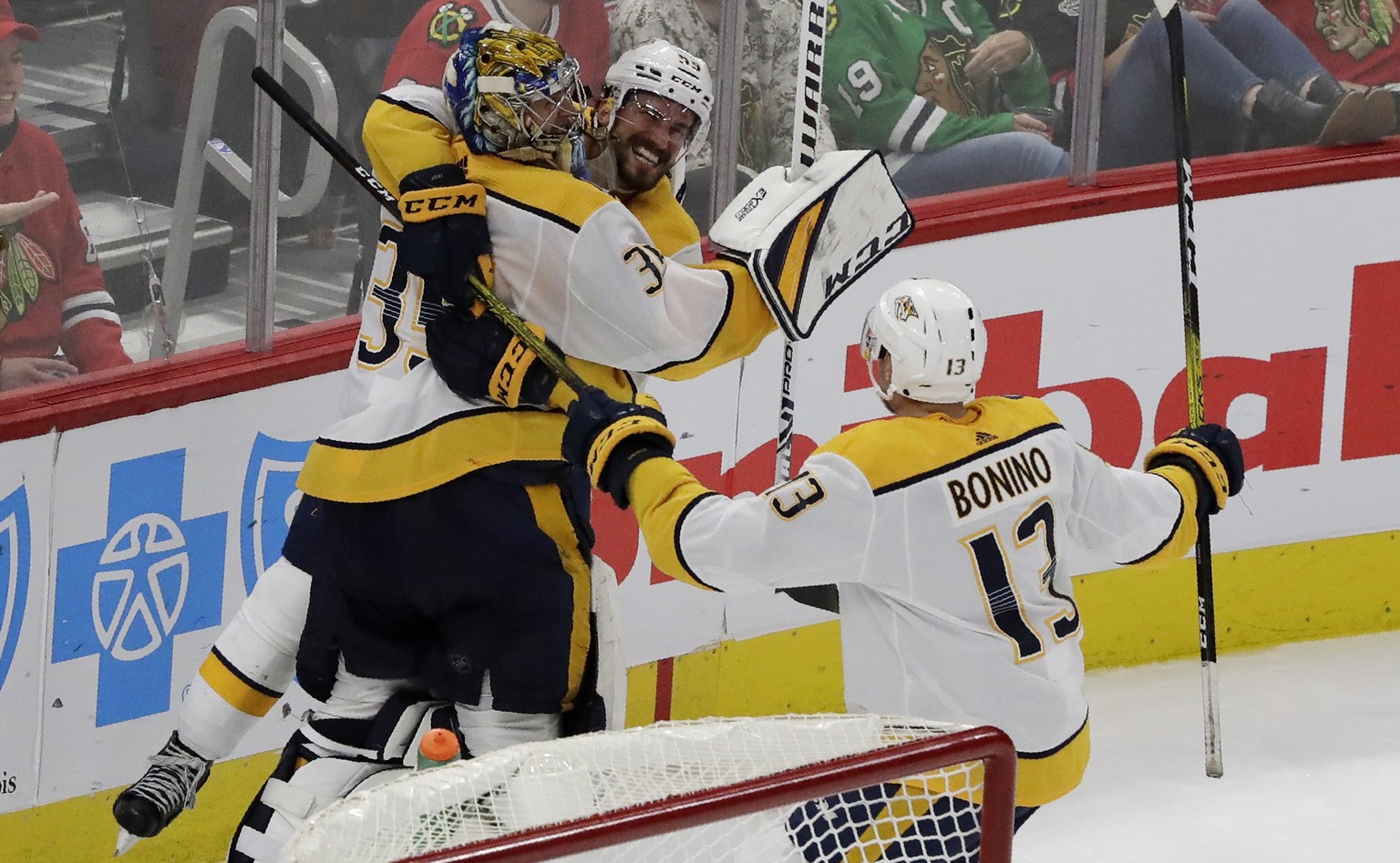 Nashville Predators goalie Pekka Rinne, left, celebrates with defenseman Roman Josi, center, and center Nick Bonino after scoring a goal against the Chicago Blackhawks during the third period of an NH ...