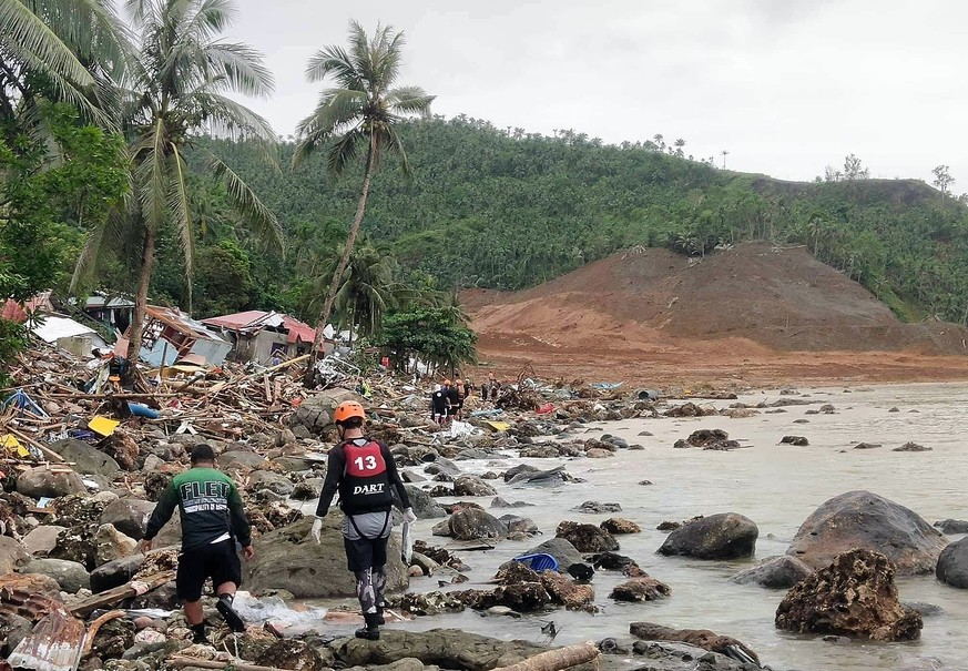epa09889369 A handout photo made available by the Philippine National Police-Abuyog Police Station (PNP-APS) shows destroyed houses and a collapsed mountain side along the coastline in the landslide-h ...