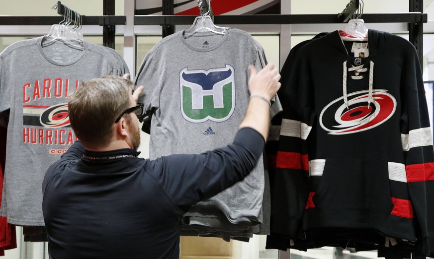 February 1, 2018 - Raleigh, NC, USA - Kurt Cusac, a worker at The Eye store, straightens out the Hartford Whalers tee shirts before the doors open before an the Carolina Hurricanes play host to the Mo ...