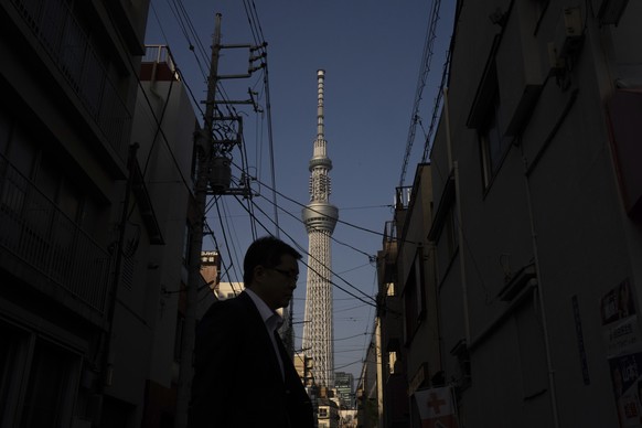 A pedestrian walks along an alley with the Tokyo Skytree in the background in Tokyo, Tuesday, May. 20, 2025. (AP Photo/Louise Delmotte)
Japan Daily Life