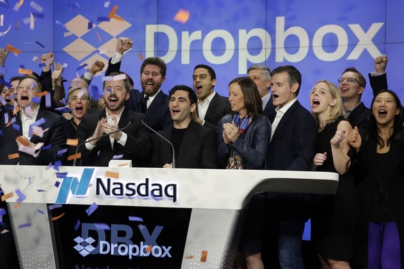 Dropbox co-founders Drew Houston, third left, Arash Ferdowsi, fourth left, and company executives celebrate as they ring the opening bell at the NasdaqMarketSite, in New York&#039;s Times Square, to c ...