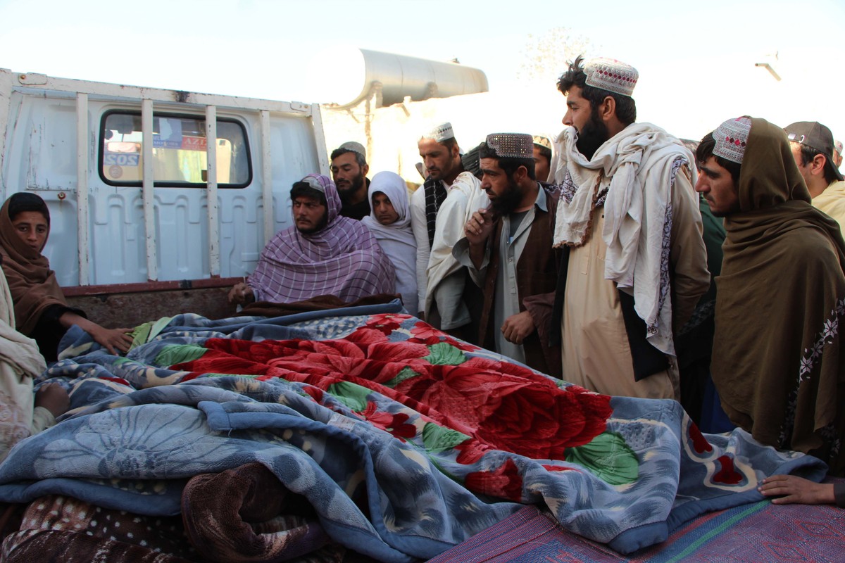 epa12510207 Afghans gather beside the bodies of people allegedly killed in cross-border fire from Pakistan at the Pak-Afghan border in Spin Boldak, Afghanistan, 07 November 2025. Afghanistan's Ta ...