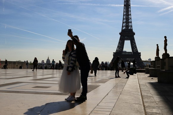 File - In this Thursday, March 30, 2017 file photo, tourists take a selfie on Trocadero with the Eiffel Tower in background on a sunny day in Paris. As of Thursday, June 15, 2017, European Union holid ...