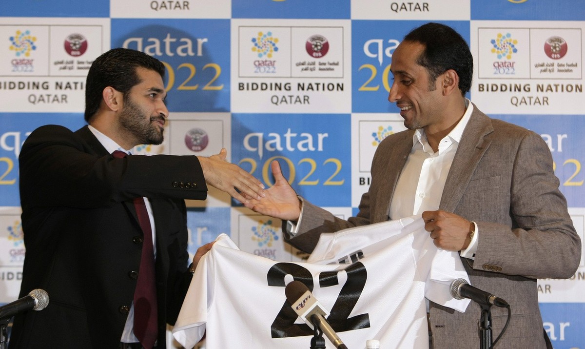 Former Saudi Arabia's striker Sami Al Jaber, right, holds his jersey as he shakes hands with CEO of Qatar World Cup 2022 Bid Committee, Hassan Abdulla Al Thawadi during a news conference announci ...