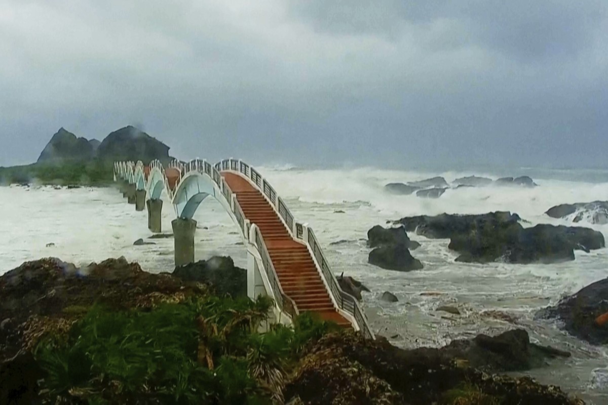 In this image made from video released by Taitung County Government, strong waves and heavy rain pound the Sansiiantai tourist spot on Aug. 13, 2025, as Typhoon Podul reaches Taitung, eastern Taiwan.  ...