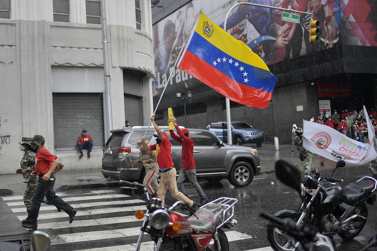 Pro-government supporters protest U.S. government imposed sanctions, marking May Day, or International Workers' Day, in Caracas, Venezuela, on a rainy Saturday, May 1, 2021, amid the new coronavi ...