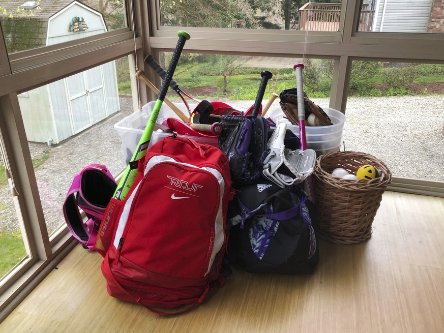 FILE - In this April 14, 2020, file photo, baseball and softball bags for Colin and Catherine Graves lie untouched in Monroeville, Pa. Doctors, scientists and sports leaders are outlining the path bac ...