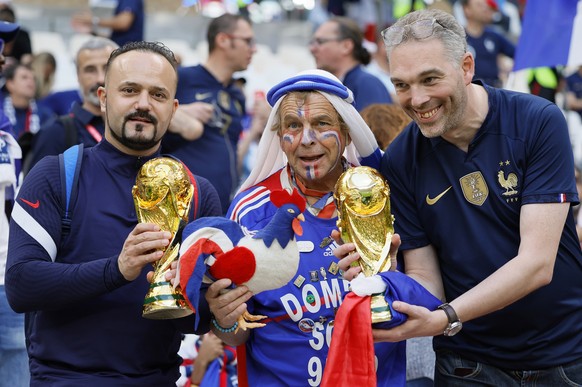 epa10371784 Fans of France pose with replicas of the World Cup trophy prior to the FIFA World Cup 2022 Final between Argentina and France at Lusail Stadium in Lusail, Qatar, 18 December 2022. EPA/Rona ...