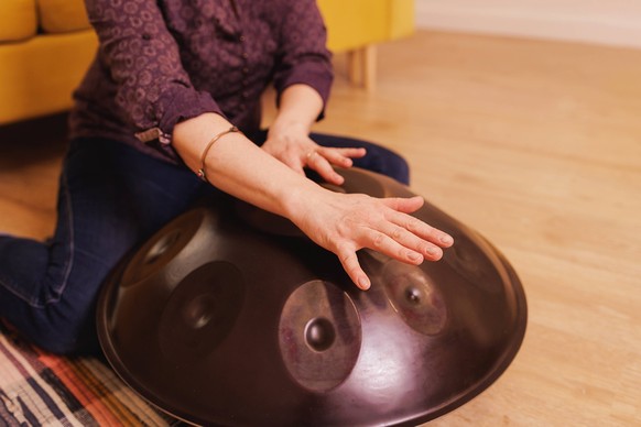 close-up of hands playing an iron drum Belarus, Mogilev Region, Belarus R_NARA230416-1171291-01 ,model released, Symbolfoto