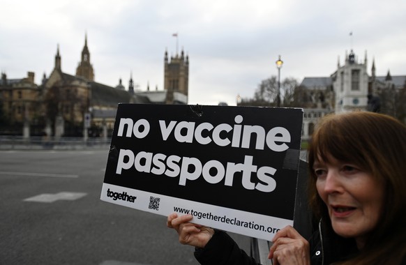 epa09641334 An anti vaccine campaigner protests against Covid passports outside parliament in London, Britain, 14 December 2021. The Parliament in England is set to vote on the controversial Covid pas ...