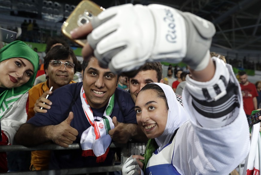 Kimia Alizadeh Zenoorin of Iran takes a selfie photo with spectators as she celebrates after winning the bronze medal in a women's Taekwondo 57-kgcompetition at the 2016 Summer Olympics in Rio de Jane ...