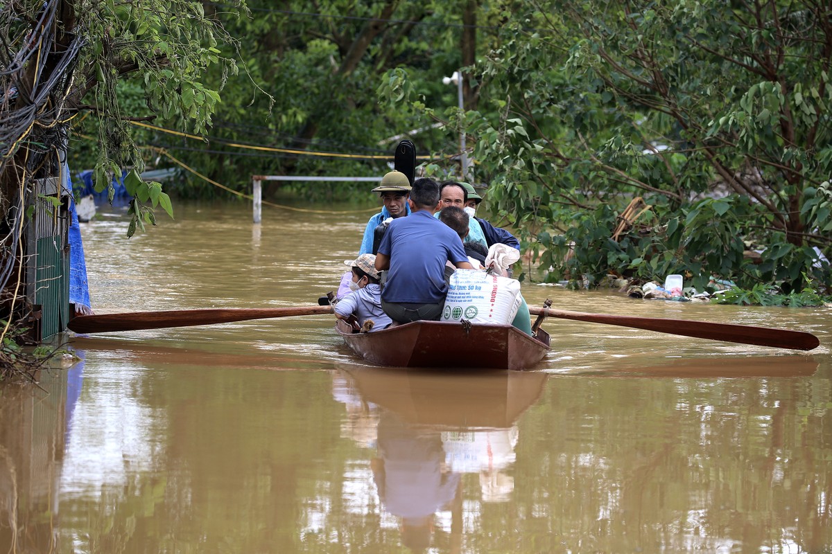 epa11596117 Local residents are evacuated with their goods on a boat at a flooded street in Hanoi, Vietnam, 10 September 2024. Typhoon Yagi, which struck northern Vietnam over the weekend, triggered s ...