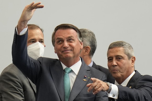 FILE - Brazilian President Jair Bolsonaro, left, and Defense Minister Walter Braga Netto attend a ceremony honoring military athletes who participated in the Tokyo 2020 Olympic Games at the military&# ...