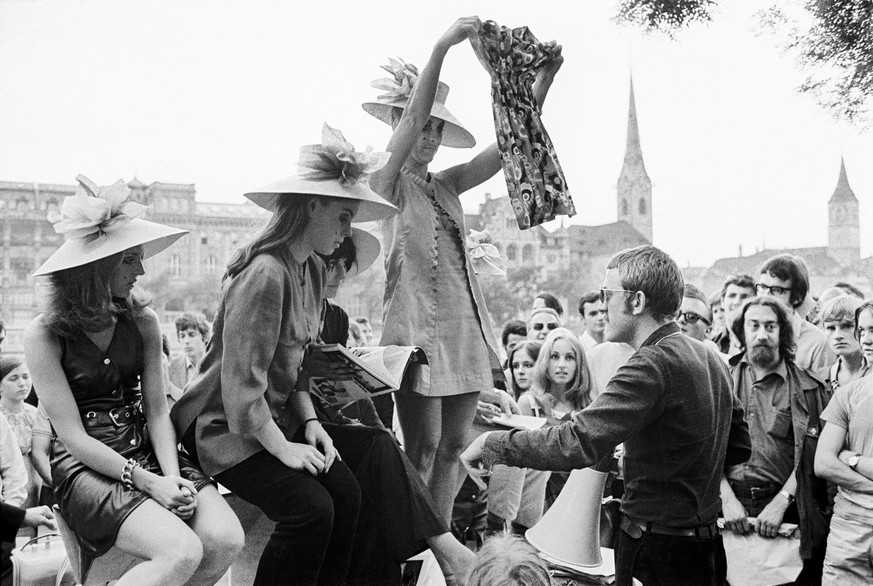 Swiss artists Verena Voiret, center left, standing, and Dieter Meier, center right, standing, and members of the women&#039;s emancipation movement FBB auction off three women&#039;s dresses including ...