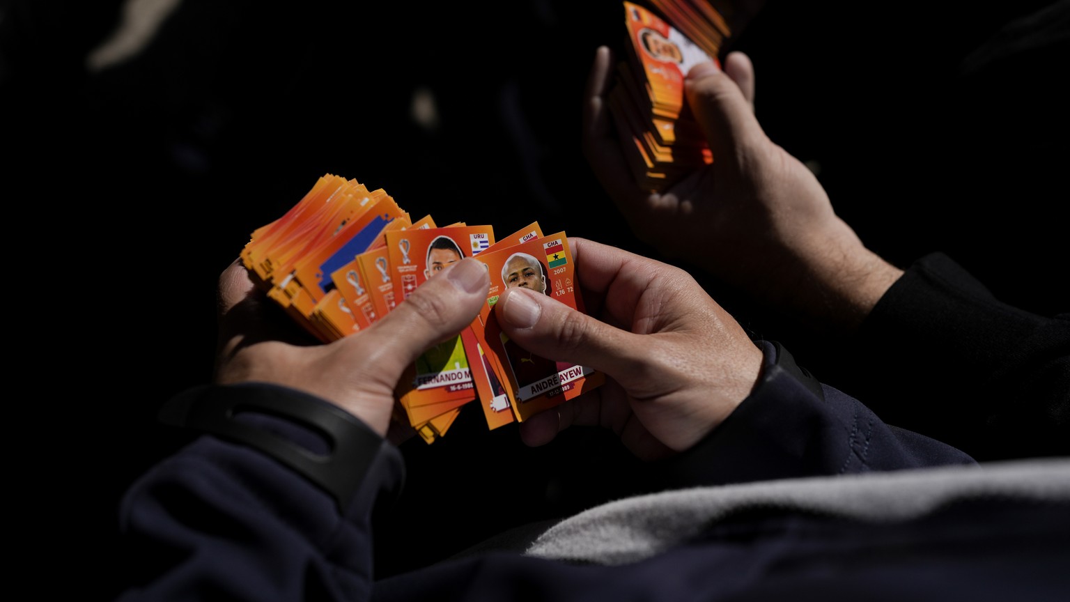 Two men exchange Panini collectible stickers for their Qatar 2022 World Cup albums at a square in Buenos Aires, Argentina, Saturday, Sept. 24, 2022. (AP Photo/Natacha Pisarenko)