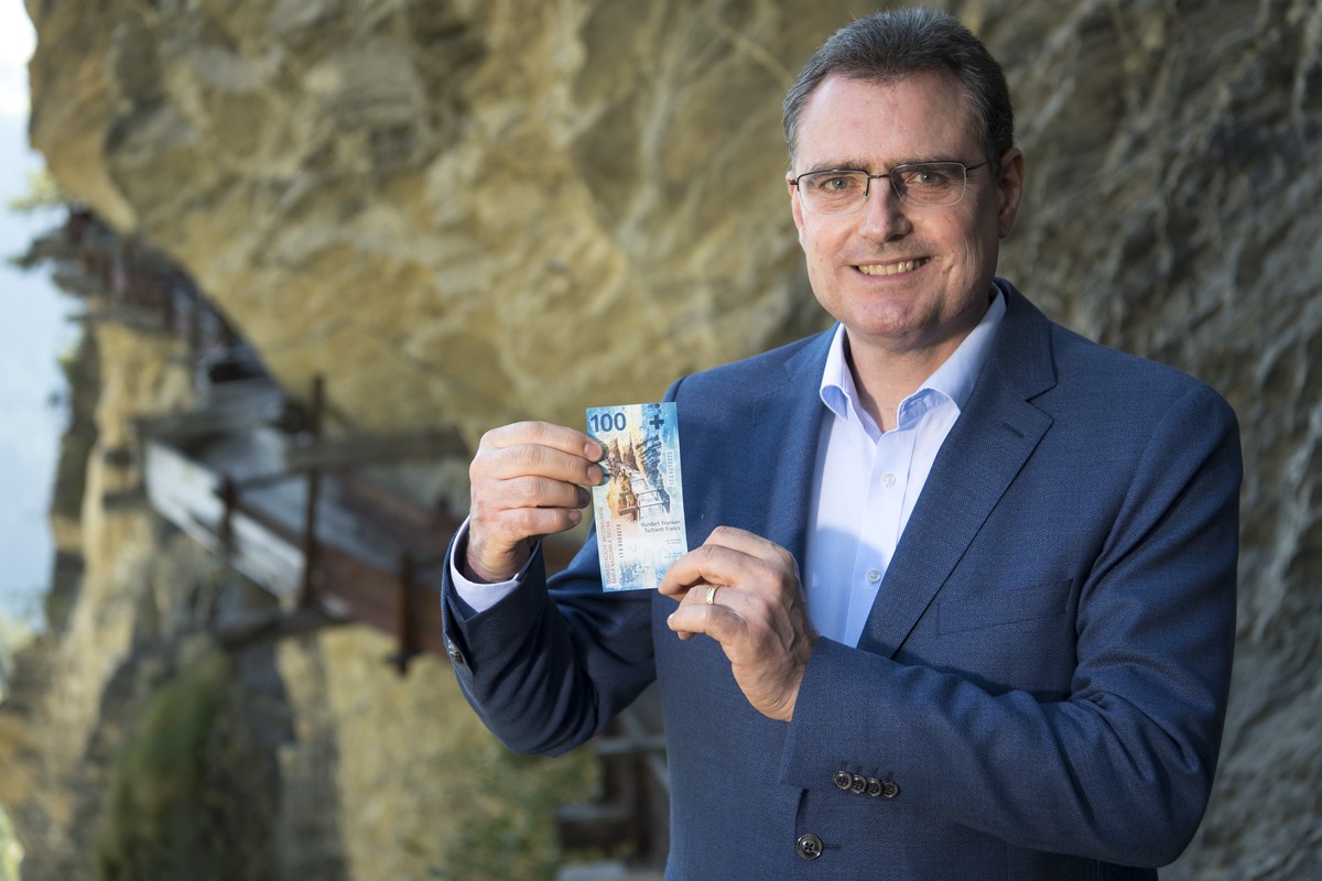 Le president de la Banque Nationale Suisse, BNS, Thomas Jordan pose avec un nouveau billet de 100 frs devant le bisse d?Ayent lors de la mise en circulation du nouveau billet de banque de 100 francs,  ...