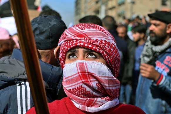 A woman waves an Iraqi flag during a protest in Tahrir Square, Baghdad, Iraq, Thursday, Feb. 13, 2020. Hundreds of women took to the streets of central Baghdad and southern Iraq on Thursday in defianc ...