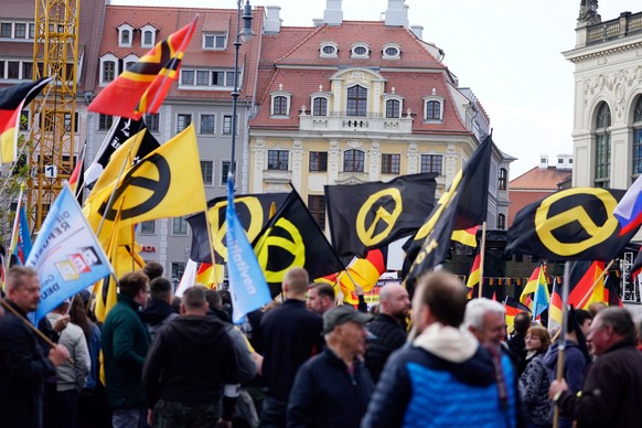 epa07109174 Supporters of the PEGIDA (Patriotic Europeans Against the Islamisation of the Occident) movement hold a flag of the far-right nationalist Identitarian Movement as they gather in Dresden, G ...
