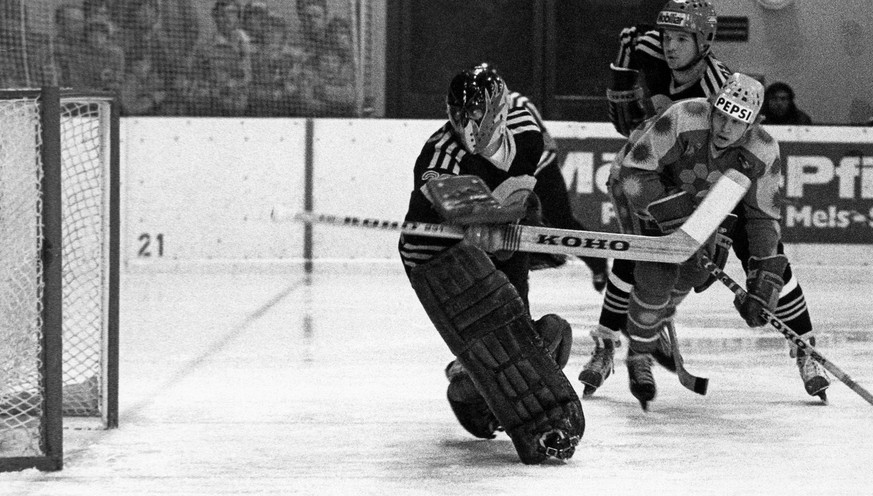 In einem hart umkaempften Spiel zwischen dem drittletzten der Tabelle, dem SC Bern, und dem Leader EHC Arosa trennten sich die Mannschaften 4 :4, aufgenommen am 17. Januar 1982. Hier wehrt SCB-Torhuet ...