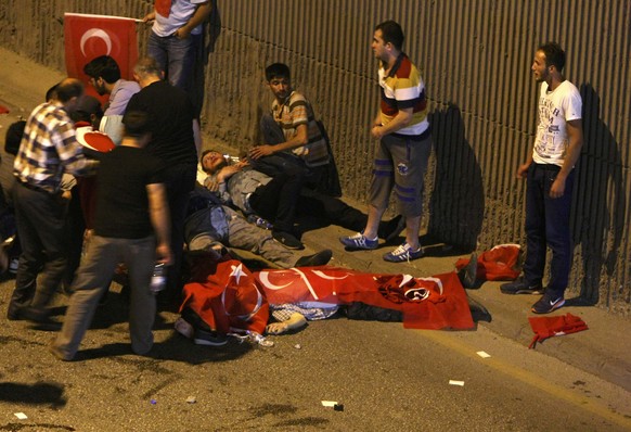 ATTENTION EDITORS - VISUAL COVERAGE OF SCENES OF INJURY OR DEATH - People react as bodies draped in Turkish flags are seen on the ground during an attempted coup in Ankara, Turkey July 16, 2016. REUTE ...