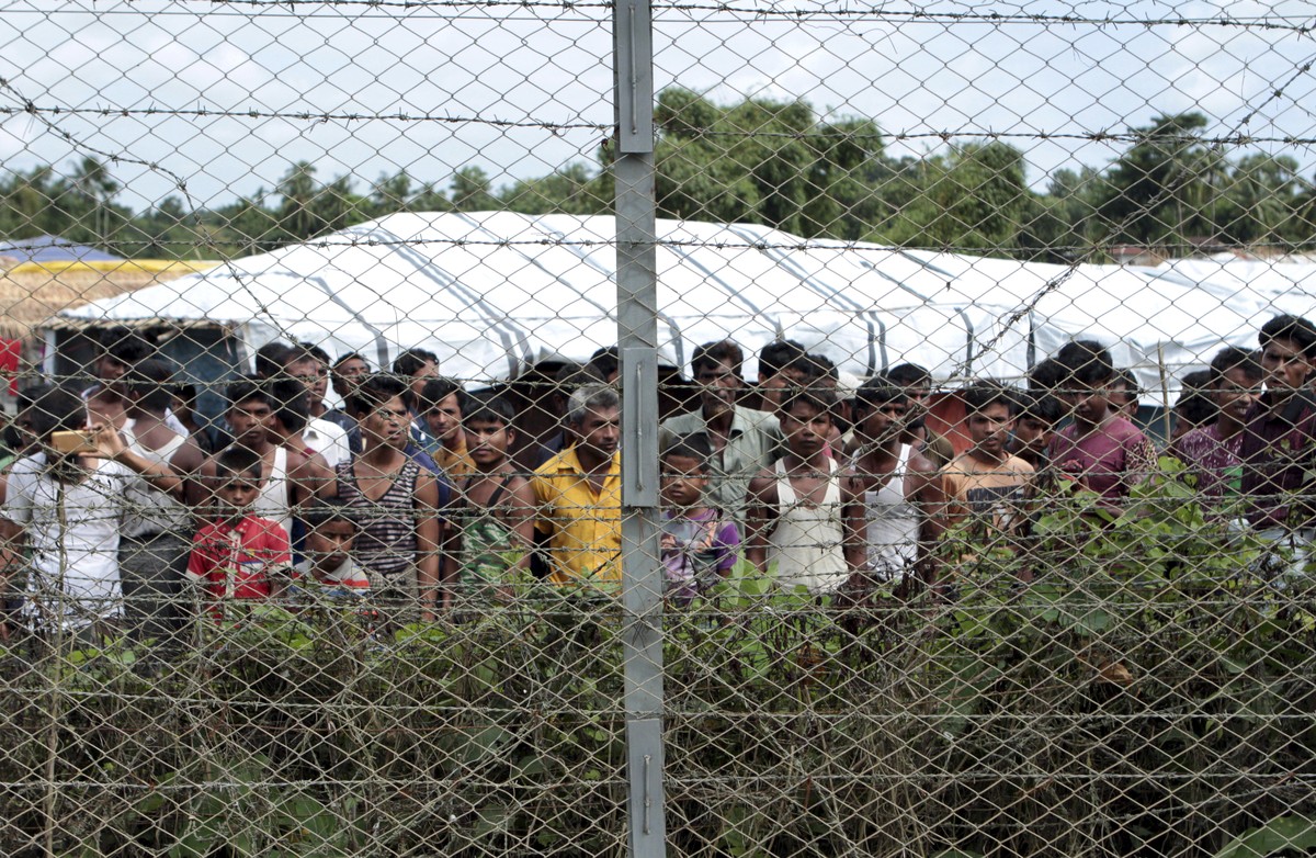FILE - Rohingya refugees gather near a fence during a government organized media tour, to a no-man's land between Myanmar and Bangladesh, near Taungpyolatyar village, Maung Daw, northern Rakhine  ...