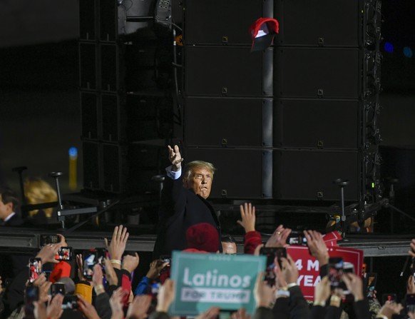 epa08710936 US President Donald J. Trump tosses hats to supporters as he arrives for a &#039;Make America Great Again&#039; election campaign rally at Duluth International Airport in Duluth, Minnesota ...