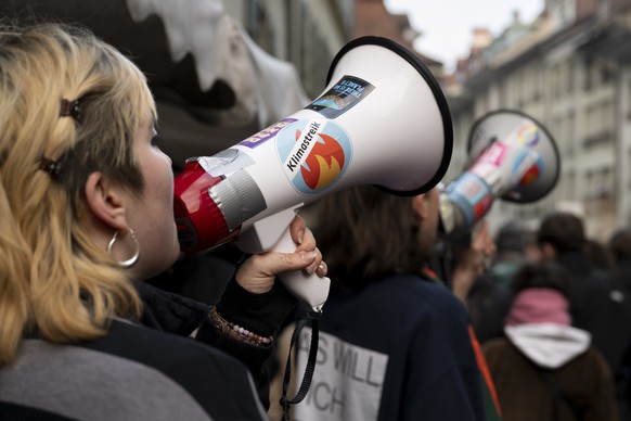 Demonstranten protestieren mit Megaphonen waehrend einem Klimastreik, am Freitag, 3. Maerz 2023 in Bern. (KEYSTONE/Anthony Anex)