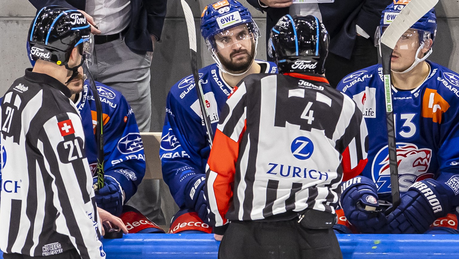 Zuerichs Trainer Marc Crawford, Mitte, diskutiert mit Schiedsrichter Lukas Kohlmueller, Mitte, und Linienrichter Michael Stalder, links, im Eishockeyspiel der National League zwischen den ZSC Lions un ...