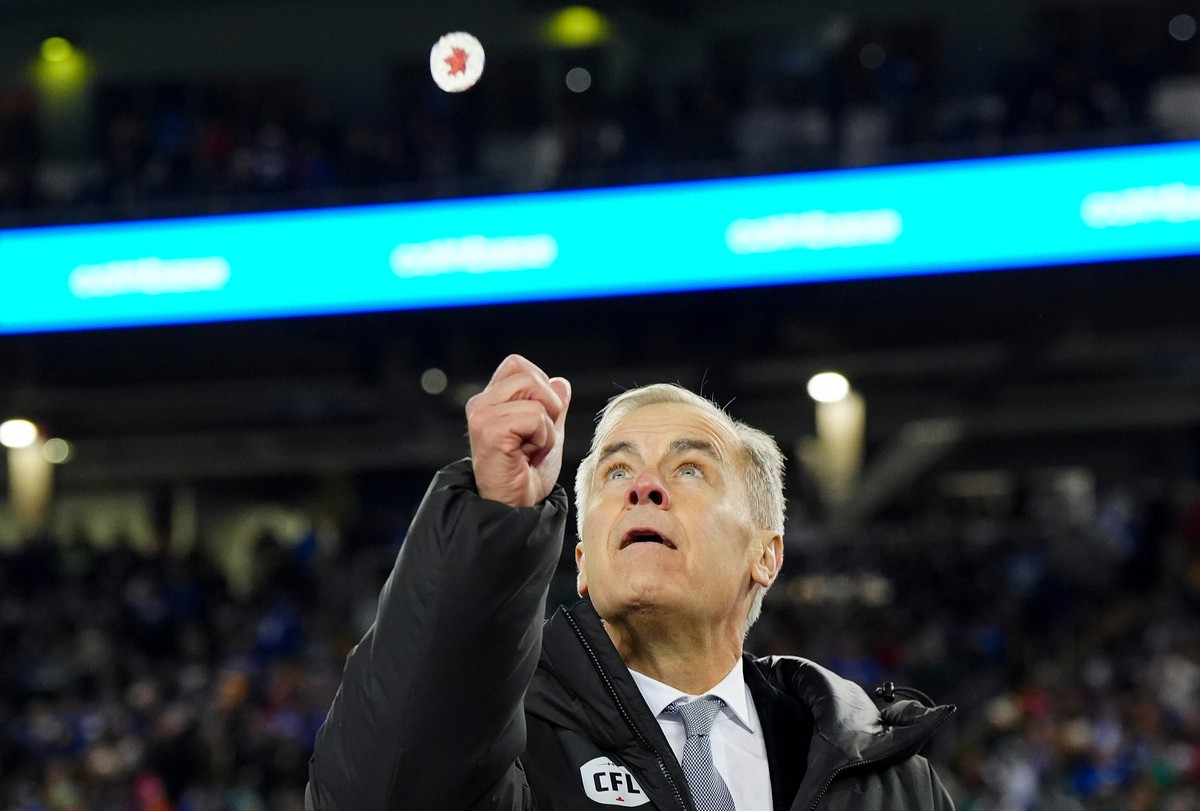 Canadian Prime Minister Mark Carney does the coin toss prior to the Montreal Alouettes taking on the Saskatchewan Roughriders in the Grey Cup football game in Winnipeg, Manitoba, Sunday, Nov. 16, 2025 ...