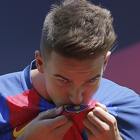 FC Barcelona&#039;s new signing Denis Suarez kisses the emblem on his shirt, during his official presentation at the Camp Nou stadium in Barcelona, Spain, Wednesday, July 6, 2016. Suarez signed with B ...