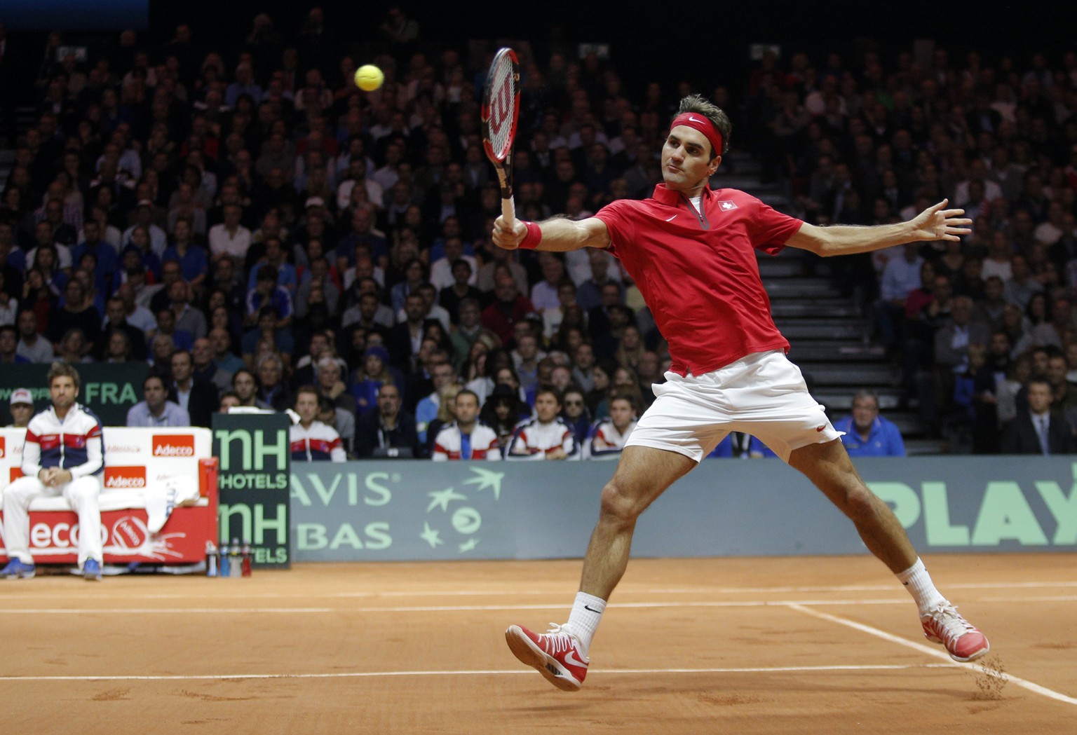 Switzerland&#039;s Roger Federer volleys the ball to France&#039;s Gael Monfils during the Davis Cup final in Lille, northern France, Friday, Nov.21, 2014. (AP Photo/Christophe Ena)