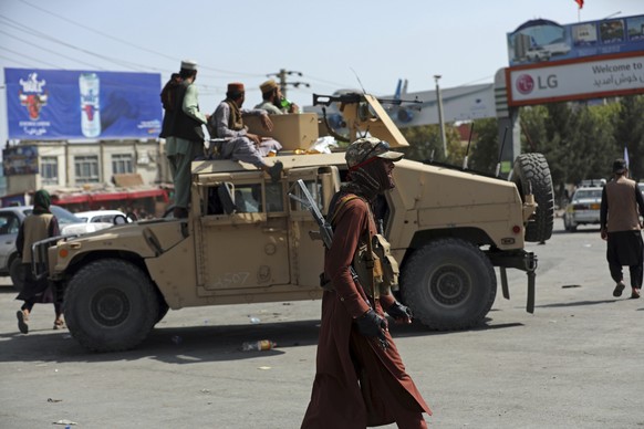 Taliban fighters stand guard in front of the Hamid Karzai International Airport, in Kabul, Afghanistan, Monday, Aug. 16, 2021. Thousands of people packed into the Afghan capital&#039;s airport on Mond ...