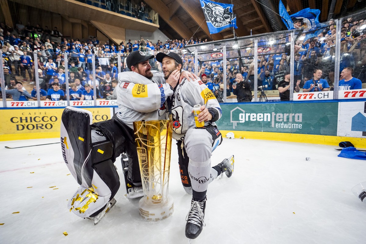 Torhueter Reto Berra und Julien Sprunger (HCFG) feiern den Meistertitel mit dem Pokal nach ihrem Sieg gegen Davos in der Verlaengerung im siebten Eishockey Playoff Finalspiel der National League zwisc ...