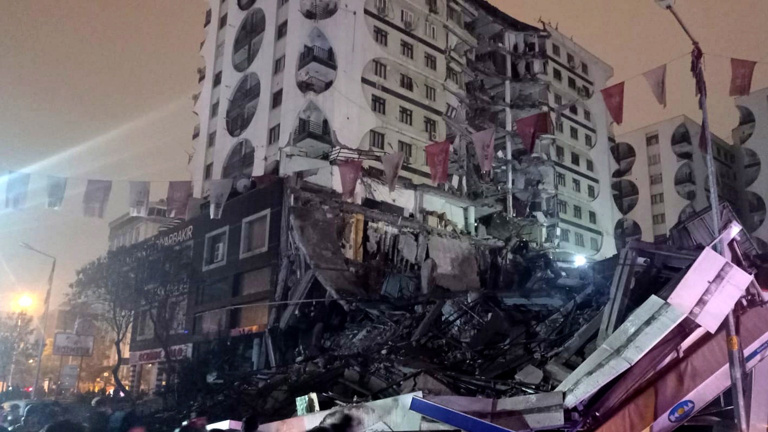 epa10450271 People try to help victims at the site of a collapsed building after an earthquake in Diyarbakir, Turkey February 06, 2023. According to the US Geological Service, an earthquake with a prel ...