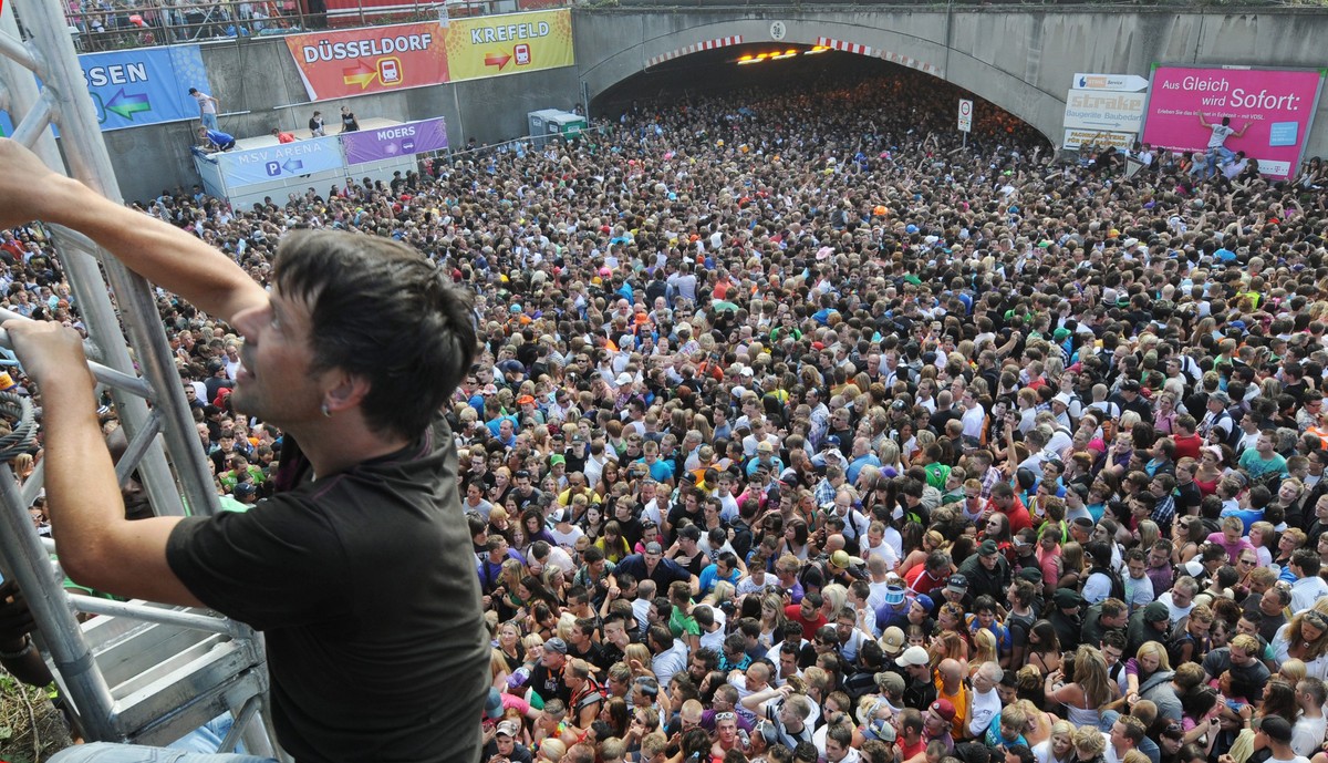 epa02260013 Thousands of ravers gather in front of a tunnel where shortly after a mass panic took place at this year's techno-music festival 'Loveparade' in Duisburg, Germany, 24 July 2 ...